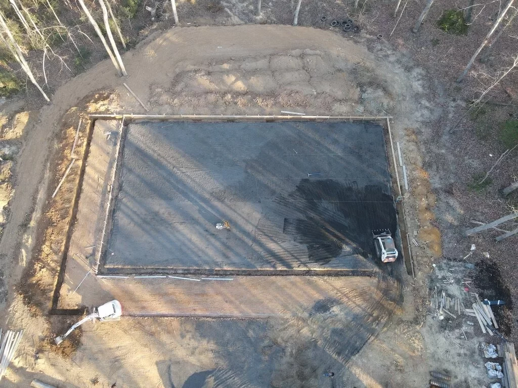 Overhead view of a poured concrete foundation slab framed out on a prepared site