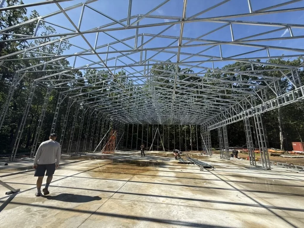 Wide-span steel-frame interior of a metal building under construction with high open clearance
