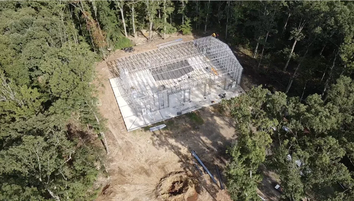 Aerial view of the steel-frame metal building under construction among the trees