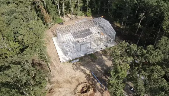 Aerial view of the steel-frame metal building under construction among the trees