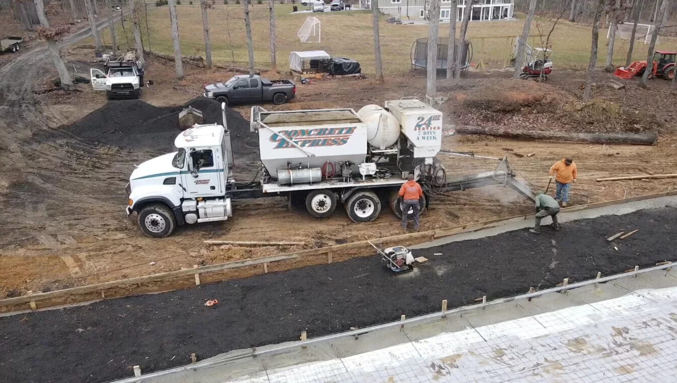 Concrete pump truck and crew pouring the foundation slab at the construction site